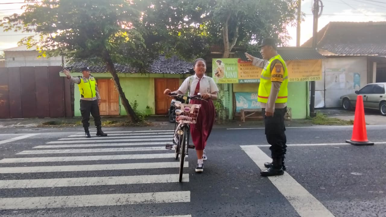 Prioritas Keselamatan Siswa, Personel Polsek Wungu Seberangkan Anak Sekolah di SDN 01 Munggut Senin Pagi